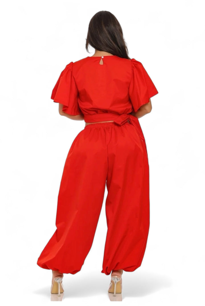 a woman wearing a red jumpsuit and a red top