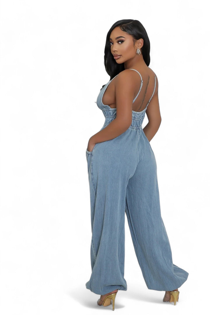 a woman in a blue jumpsuit posing for a picture