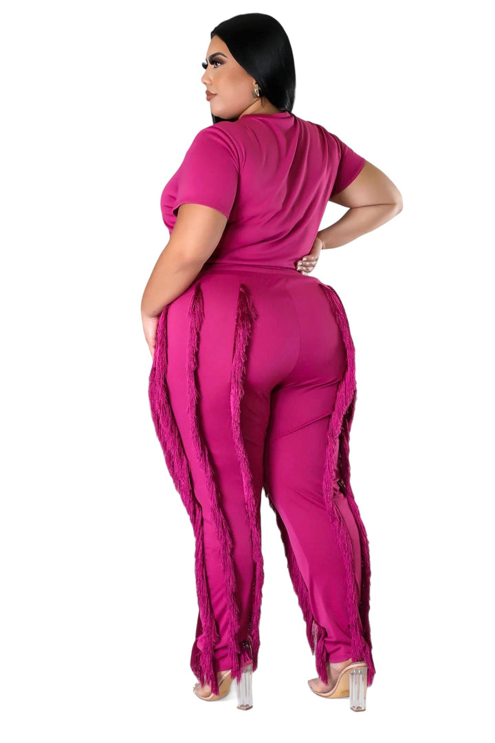 a woman in a pink jumpsuit and heels