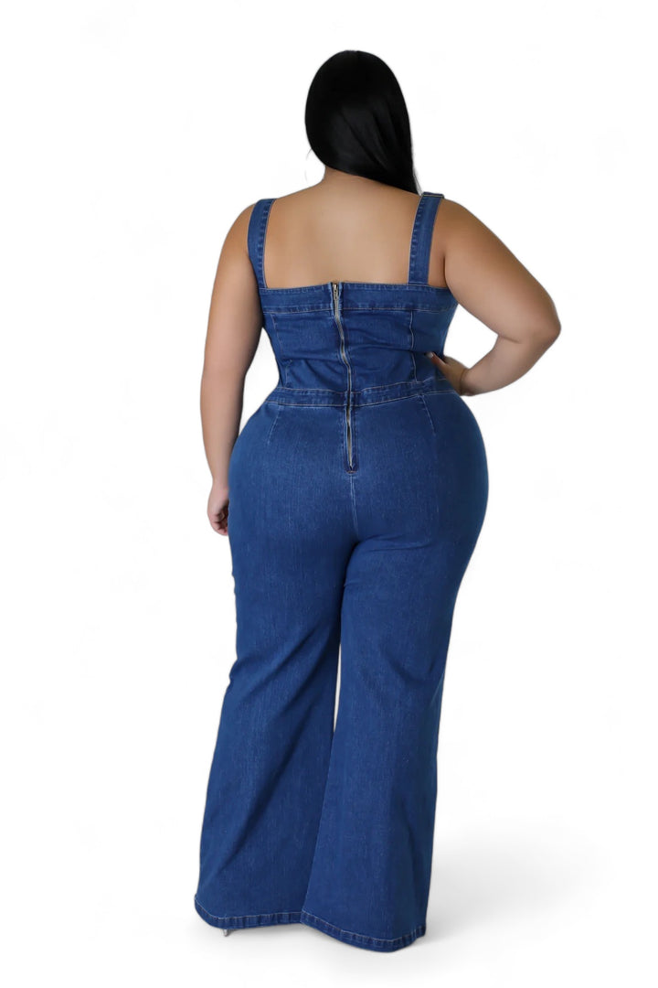 a woman in a denim jumpsuit with her back to the camera
