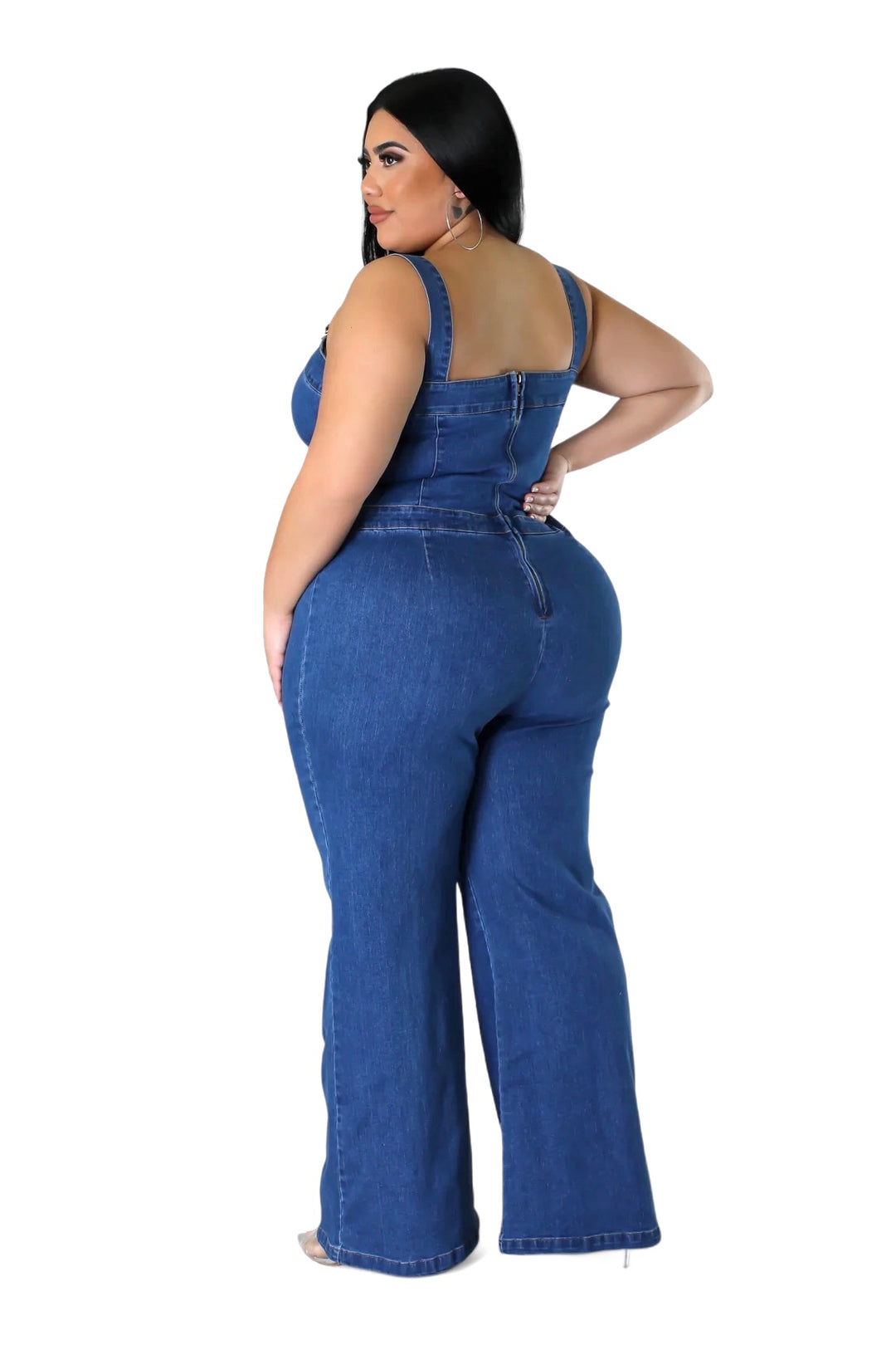 a woman in a denim jumpsuit with her hands on her hips
