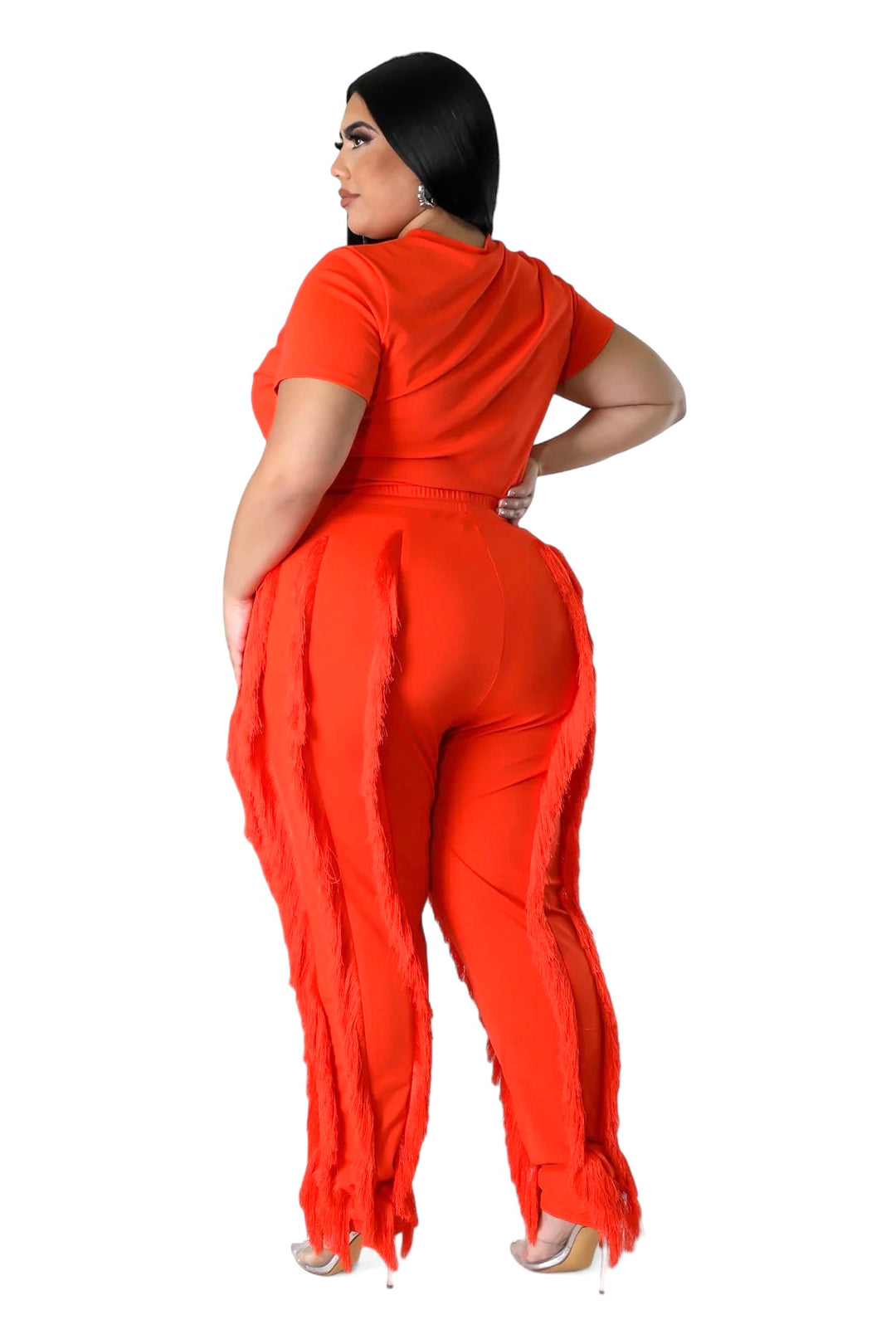 a woman in an orange jumpsuit with her hands on her hips