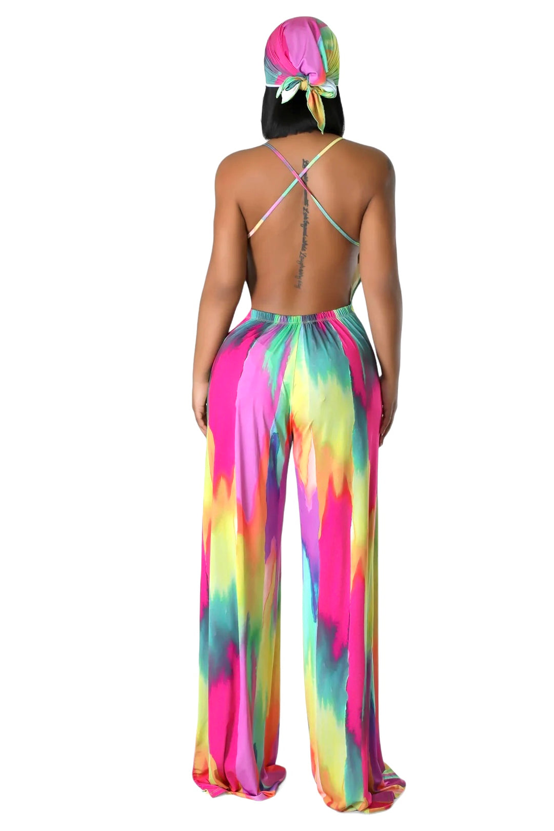 the back of a woman wearing a colorful tie dye jumpsuit