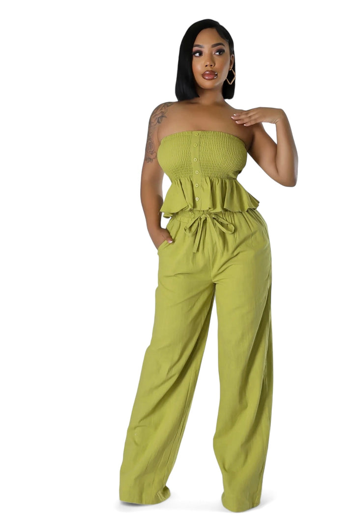 a woman in a green strapless top and wide legged pants