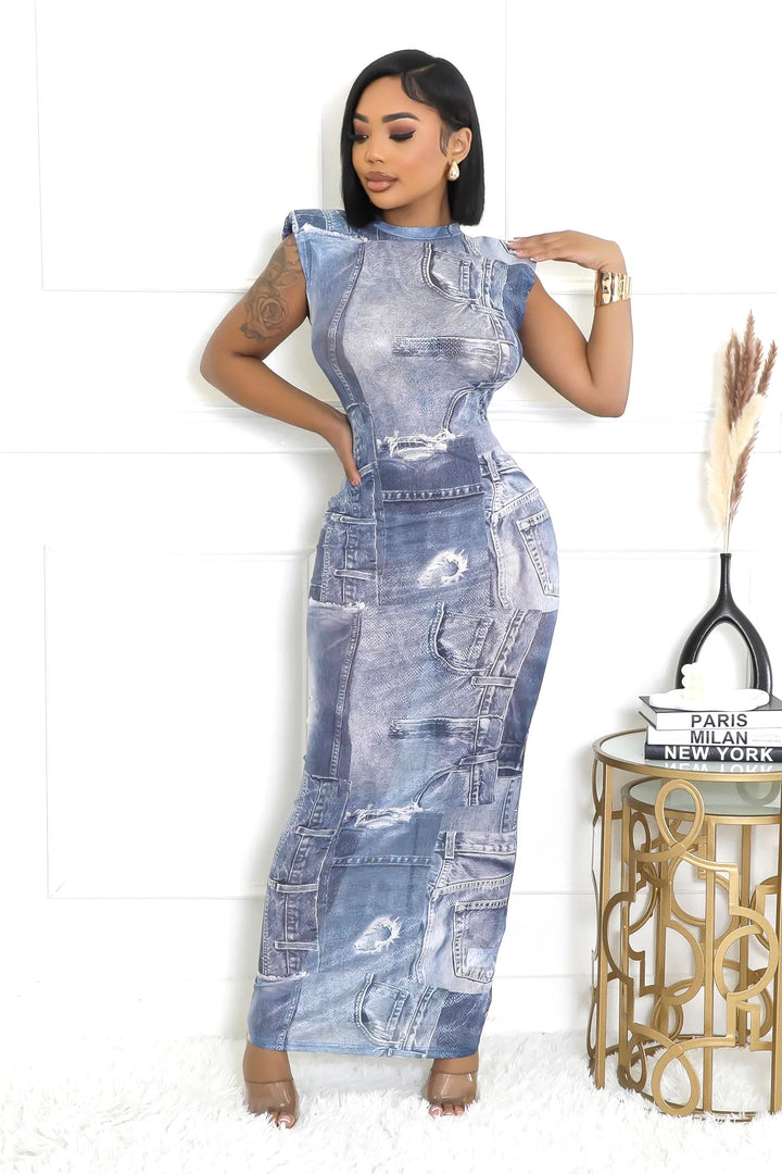 a woman in a denim dress standing next to a table