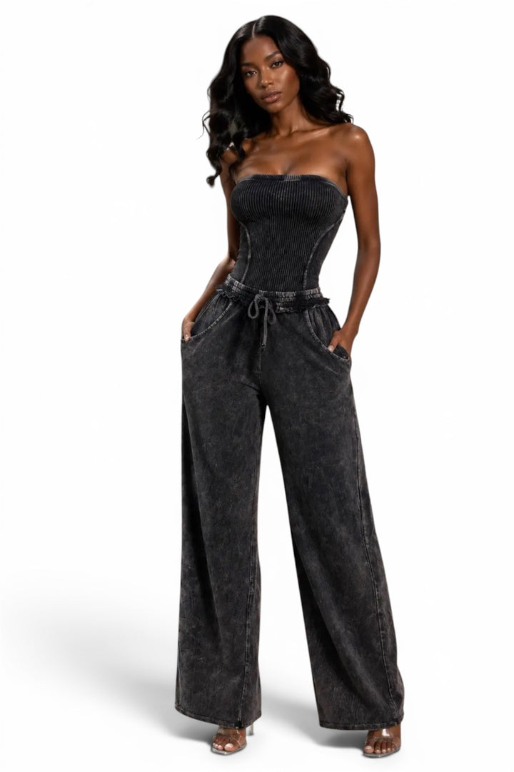 Black strapless denim jumpsuit for women featuring a fitted corset-style bodice, wide-leg pants, drawstring waist, and side pockets.