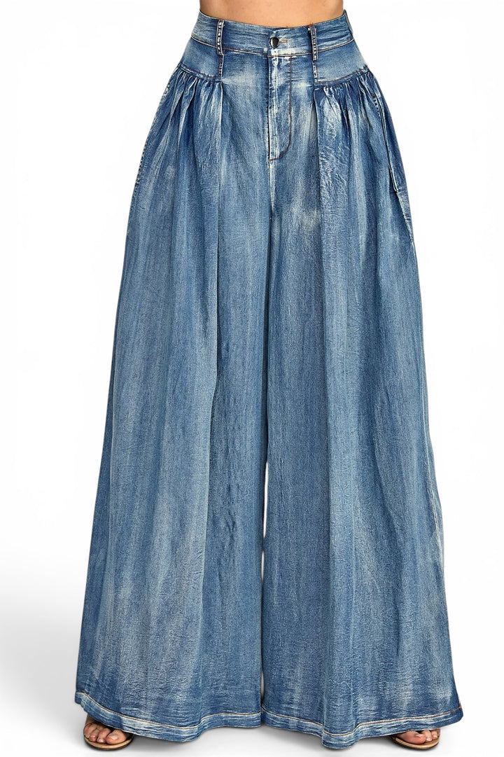 Medium wash high-rise denim palazzo jeans featuring elegant front pleats, an ultra-wide leg silhouette, and a relaxed flowing fit.
