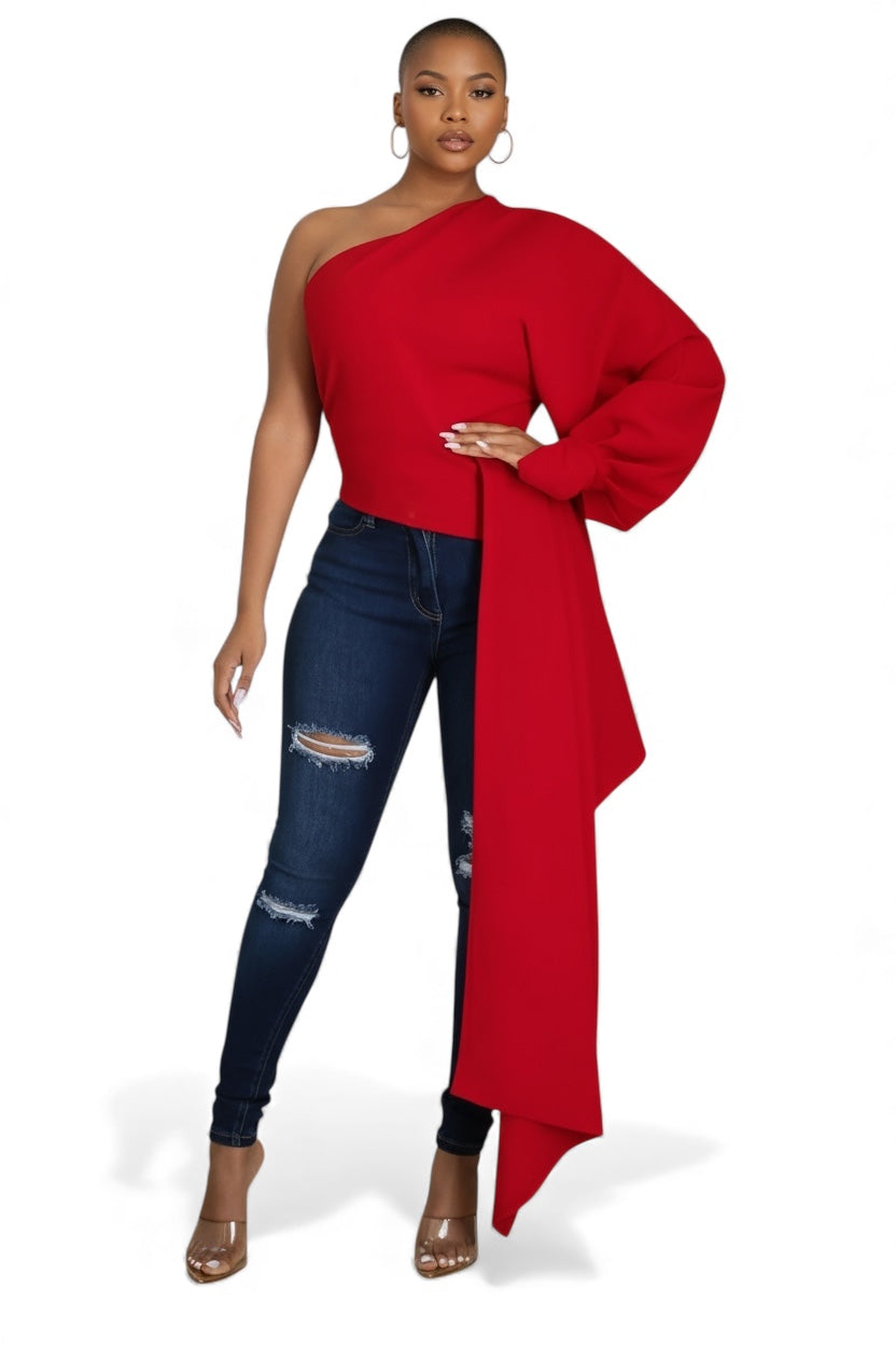 Woman wearing a red one-shoulder top and blue jeans on a white background