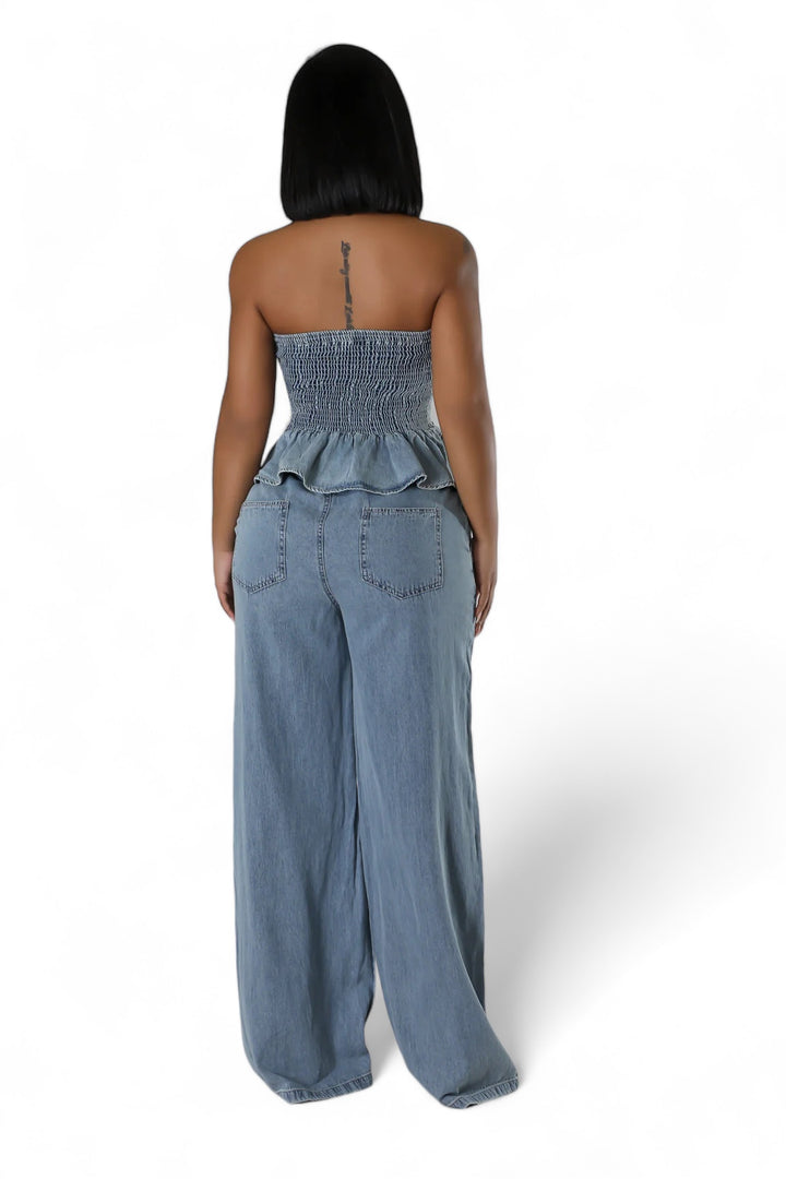 a woman wearing a denim jumpsuit with a strap