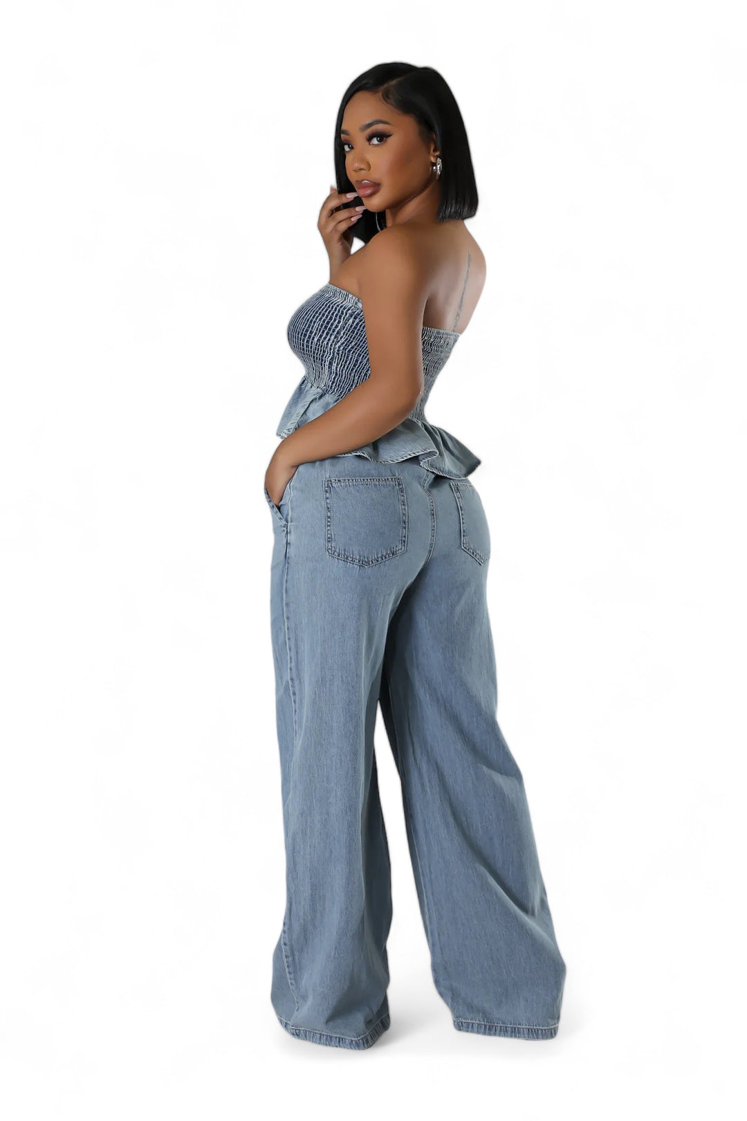 a woman in a denim jumpsuit talking on a cell phone