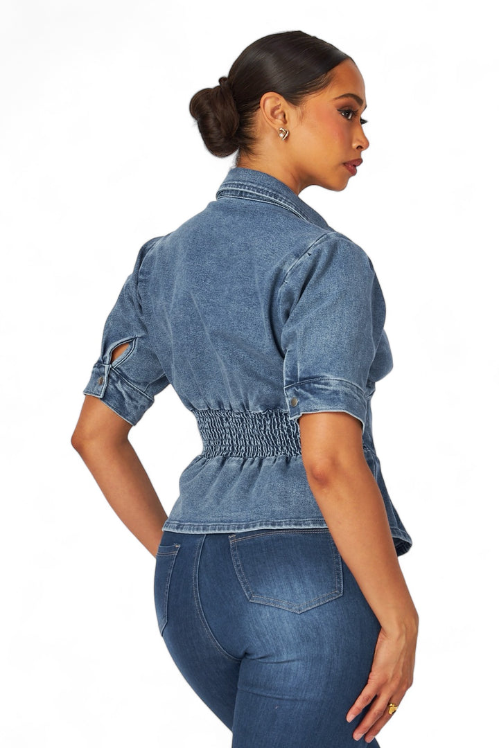 a woman wearing a denim shirt and jeans