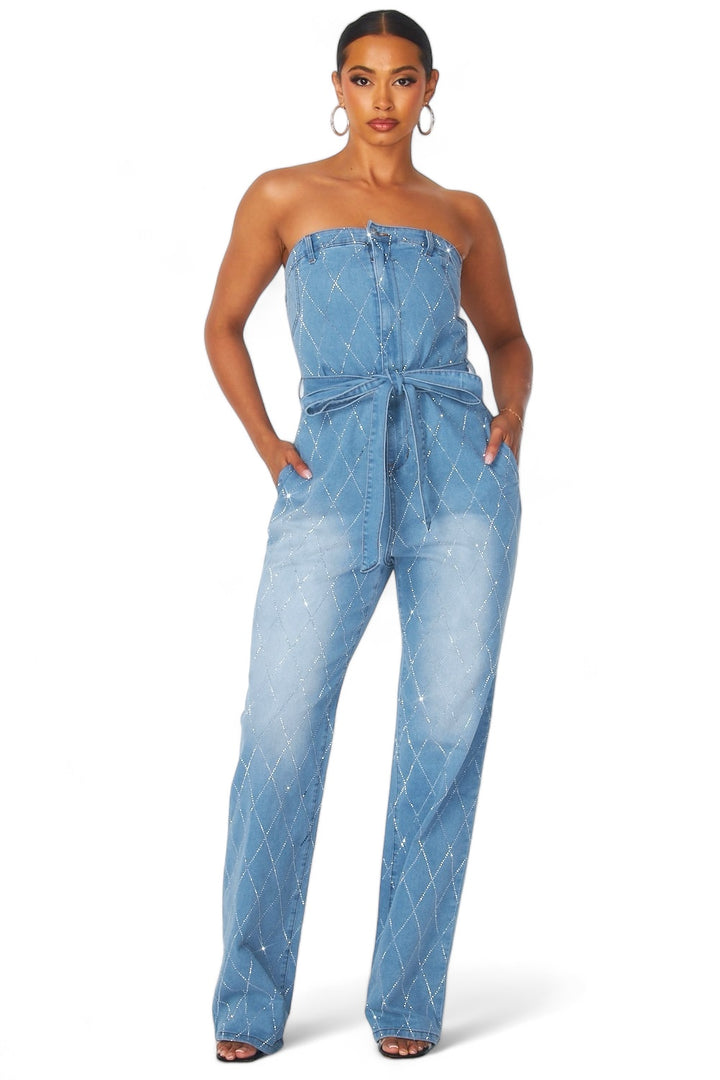 a woman wearing a denim jumpsuit with a strap