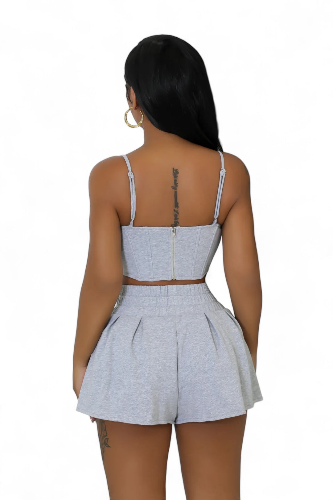 the back of a woman wearing a grey top and shorts