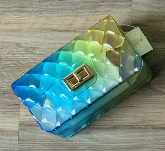a multicolored purse sitting on top of a wooden floor